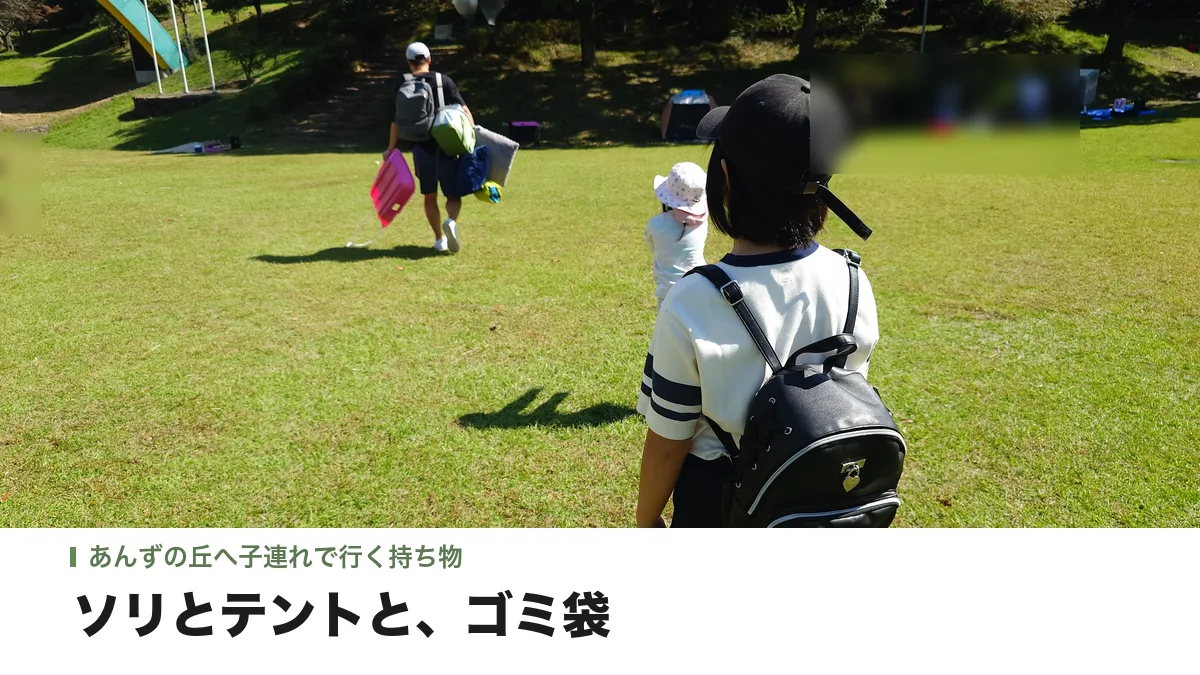ソリやテントを持って、あんずの丘の芝生広場へ向かう親子の後ろ姿