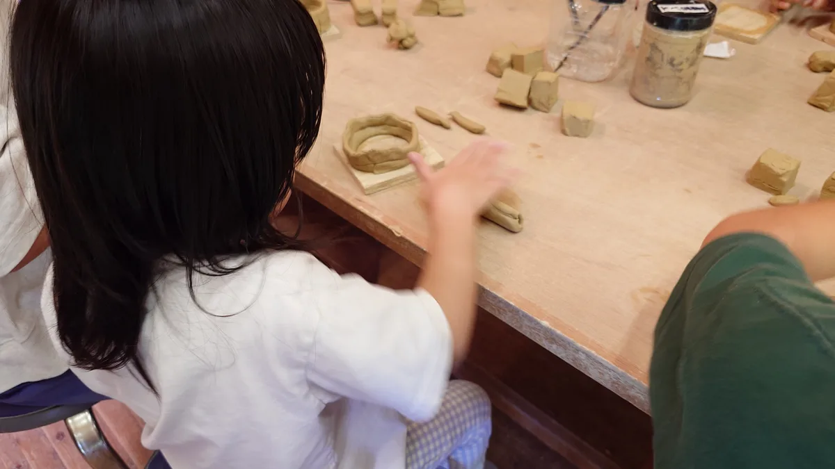 古代生活体験館で粘土をこねて埴輪を作る子ども
